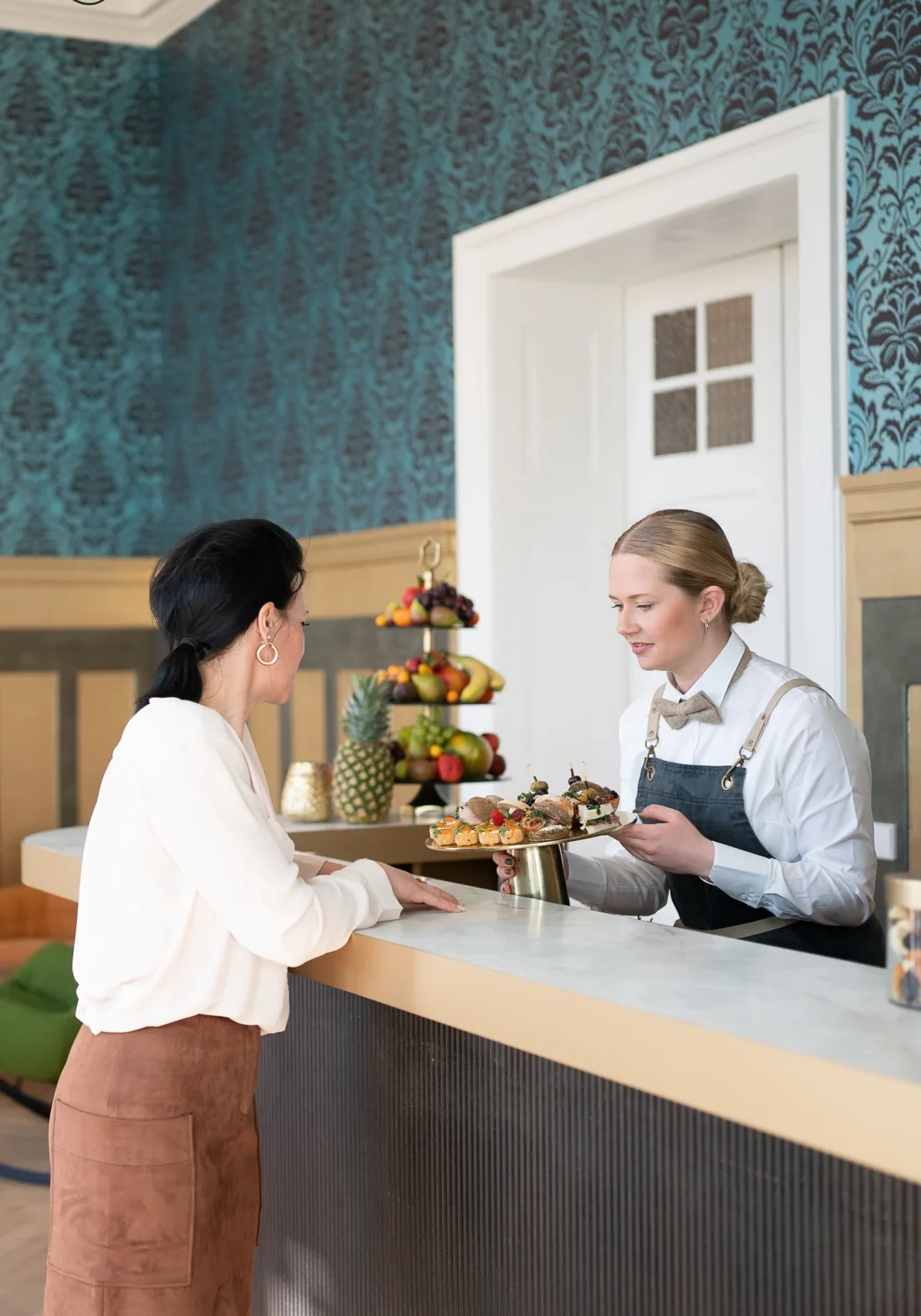 Servicekraft bietet Häppchen am Tresen an