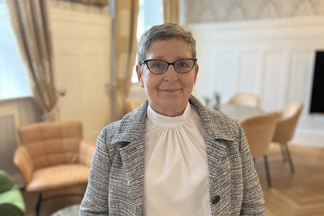 aeltere-frau-brille-graues-haar-elegantes-interieur
